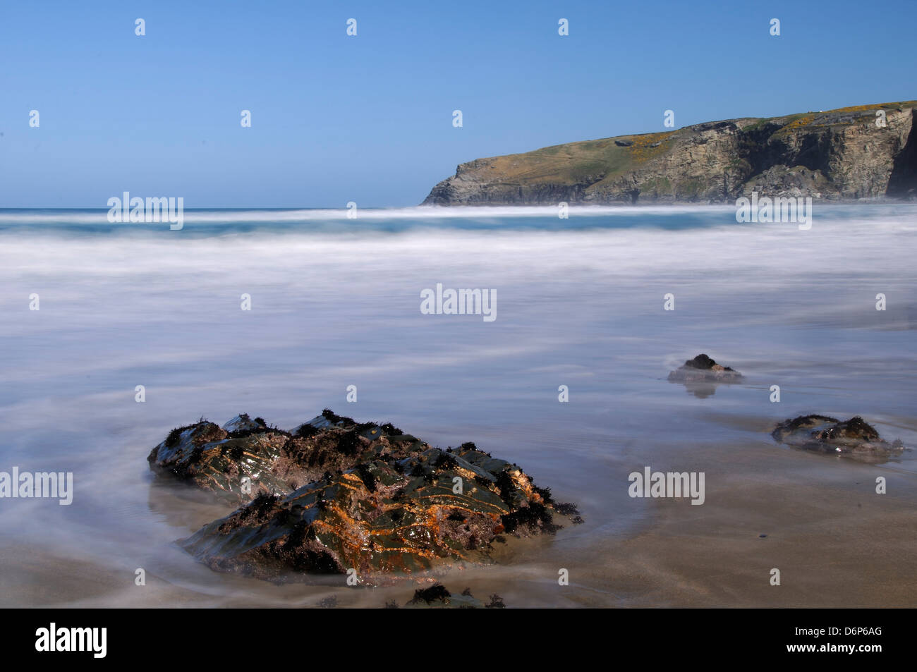 Eine steigende Flut wirbelt um einen Felsen am Strand von Trebarwith Strand, Cornwall, England, Vereinigtes Königreich, Europa Stockfoto