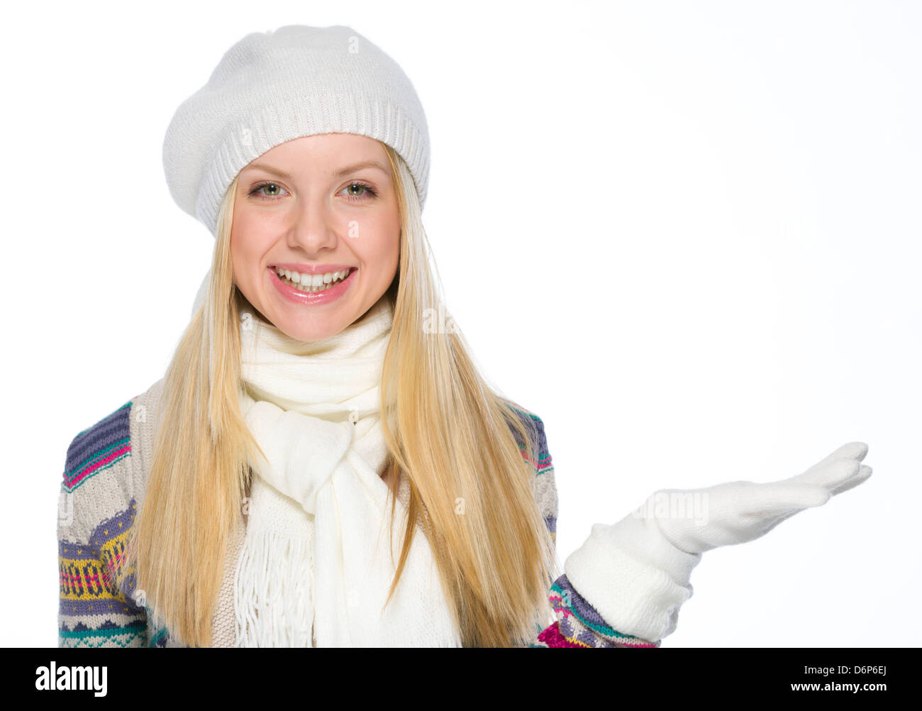 Lächelndes Mädchen in Winterkleidung präsentiert etwas auf der leeren Seite Stockfoto
