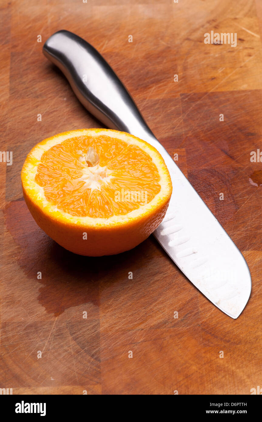 Orangenscheibe mit Messer Stockfoto