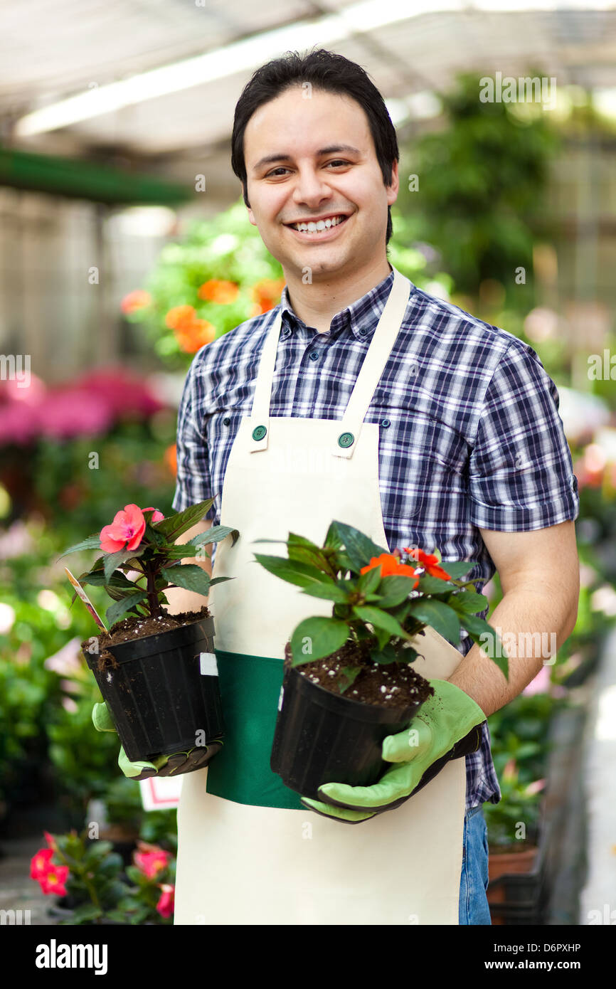 Porträt eines lächelnden Gewächshaus Arbeitnehmers holding Blumentöpfe Stockfoto