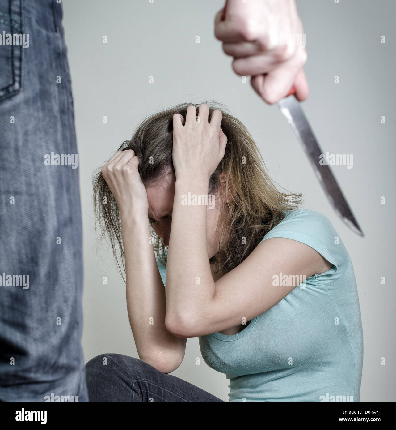 Mann mit Messer kommt zu seiner Frau. Home-Gewalt-Konzept Stockfoto
