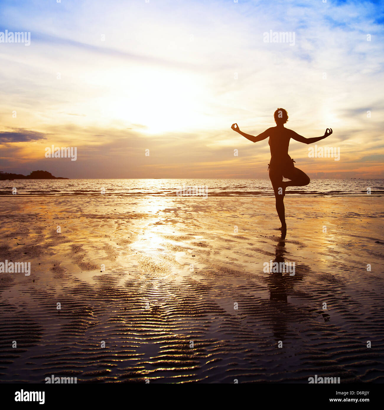 Wellness Konzept, wunderschönen Sonnenuntergang am Strand, Frau, Yoga zu praktizieren Stockfoto