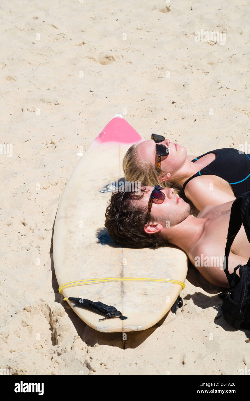 Menschen entspannen mit einem Surfbrett am Strand von Manly Beach in Australien Stockfoto