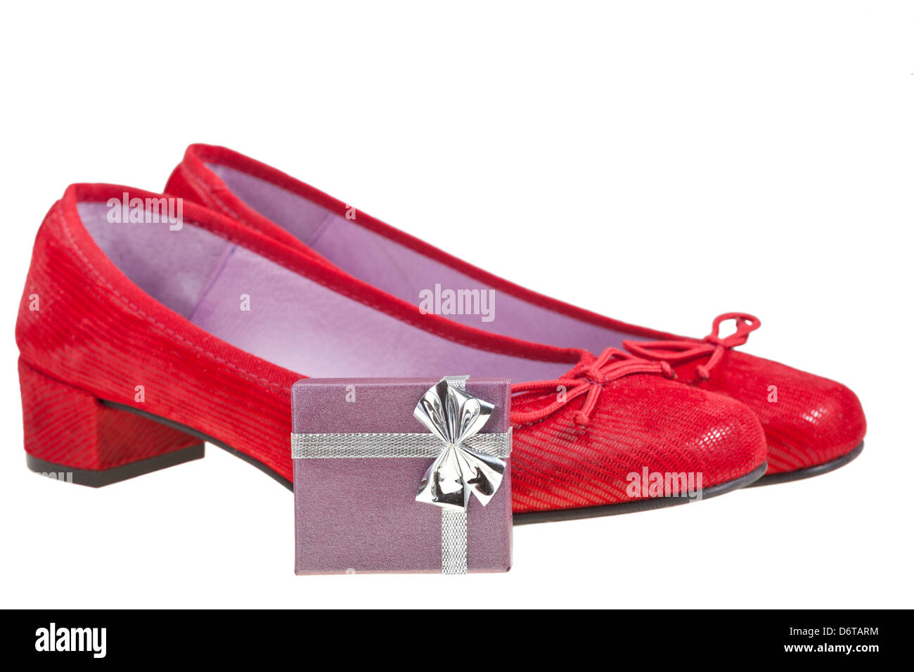 paar rote Frauenschuhe mit kleinen Geschenkbox isoliert auf weißem Hintergrund Stockfoto