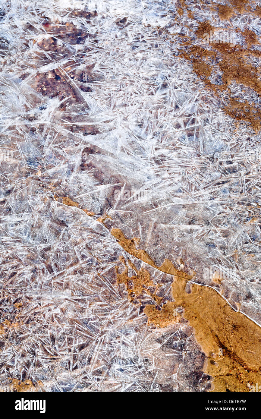 Eiskristalle unter dem gefrorenen Wasser im Frühlingsmorgen Stockfoto