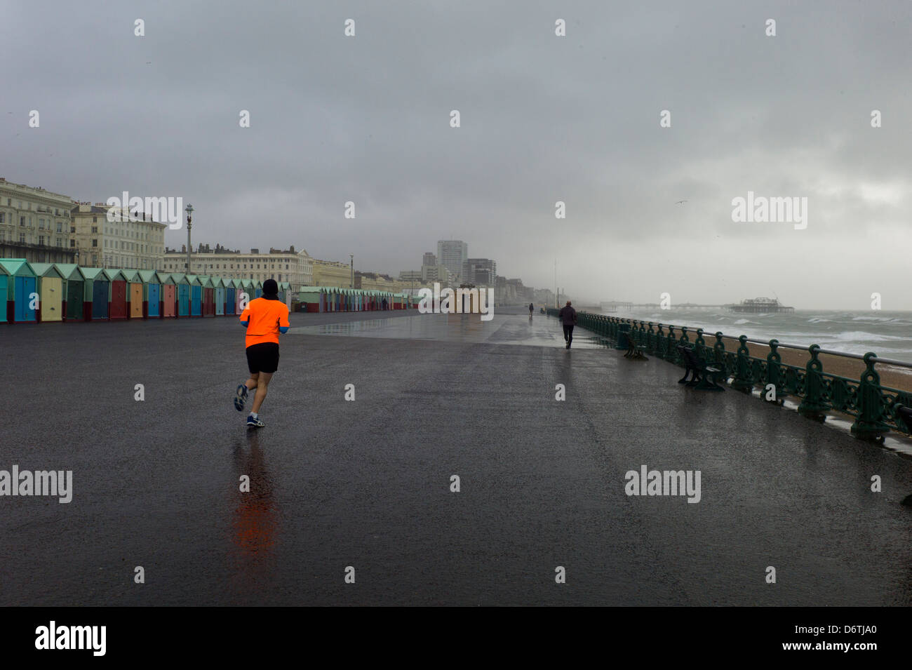 Jogger in Leuchtweste, Regen, Meer, Brighton, uk Stockfoto