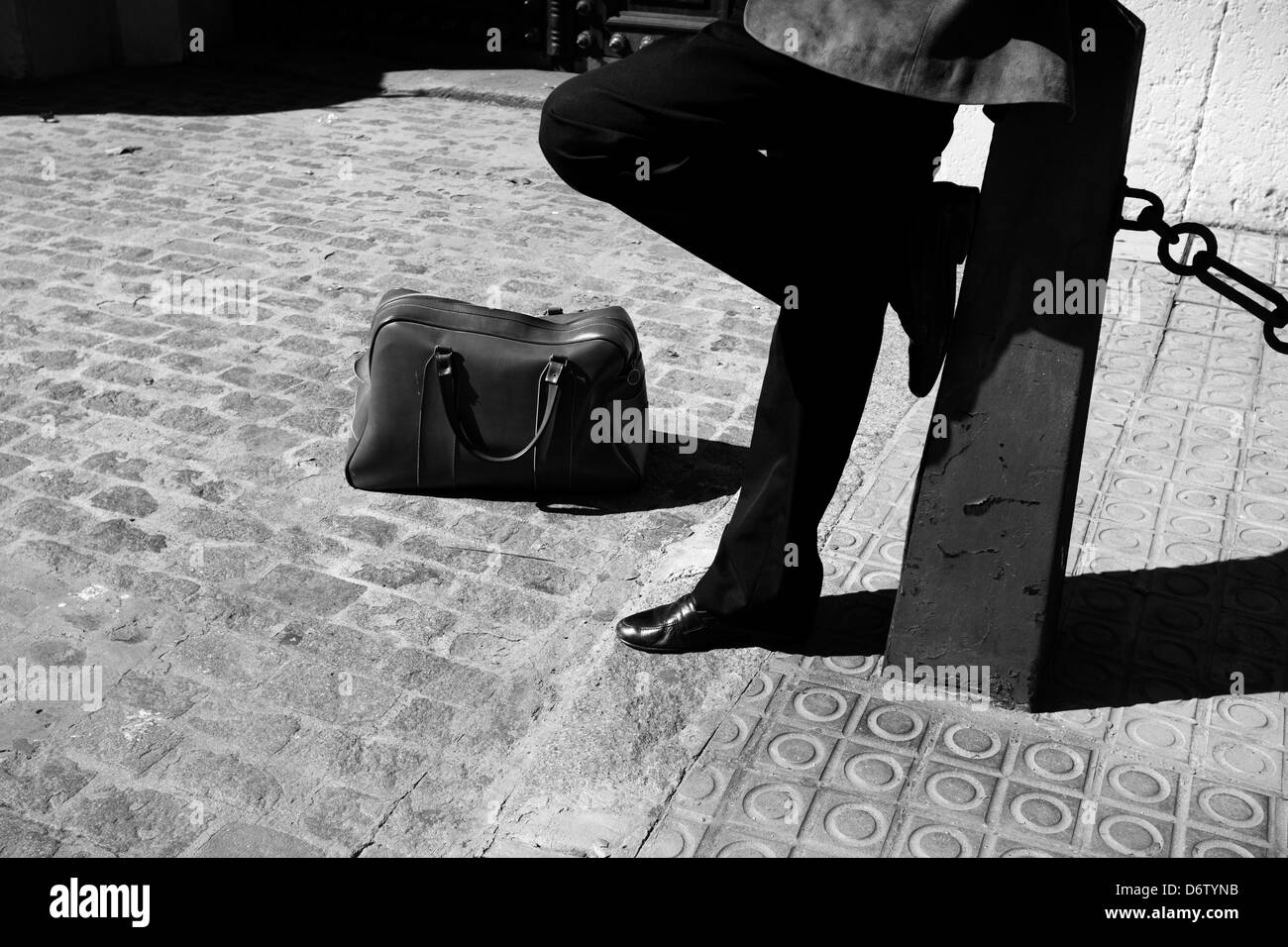 Ein Mann wartet mit Koffer, bevor die Stadt verlassen. Stockfoto