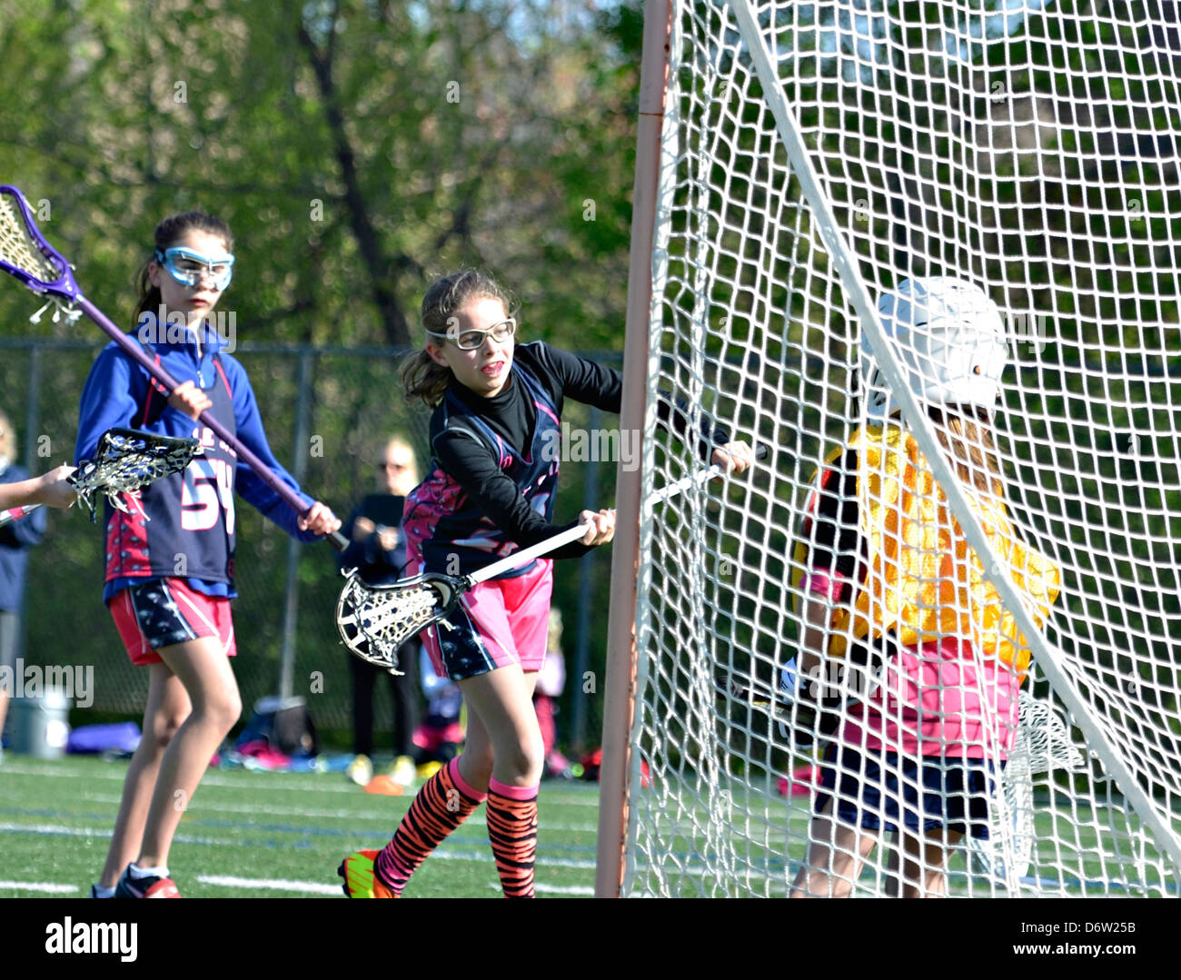 Junge Mädchen Lacrosse-Spieler macht eine Anspielung auf das Ziel, einen Punkt zu erzielen. Stockfoto