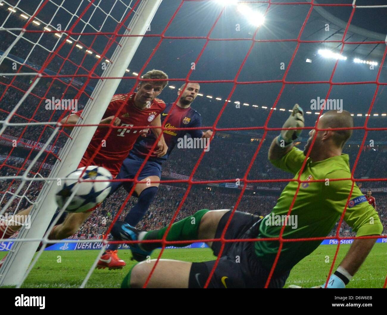 Münchner Thomas Müller (L) erzielt das 1:0 gegen Barcelonas Gerard Pique (C) und Halter Victor Valdes (R) während der UEFA-Champions-League-Halbfinale ersten Bein Fußballspiel zwischen FC Bayern München und FC Barcelona in der Arena in München, 23. April 2013. Foto: Peter Kneffel/Dpa +++(c) Dpa - Bildfunk +++ Stockfoto