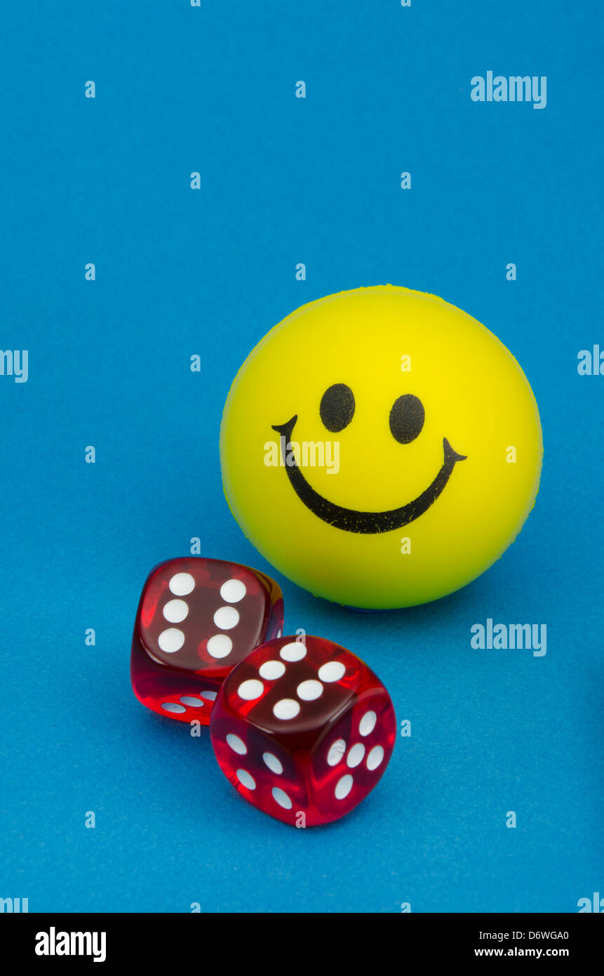 Glücklich gelben Smiley-Gesicht mit ein paar roten Würfel zeigt eine Rolle von zwölf Stockfoto