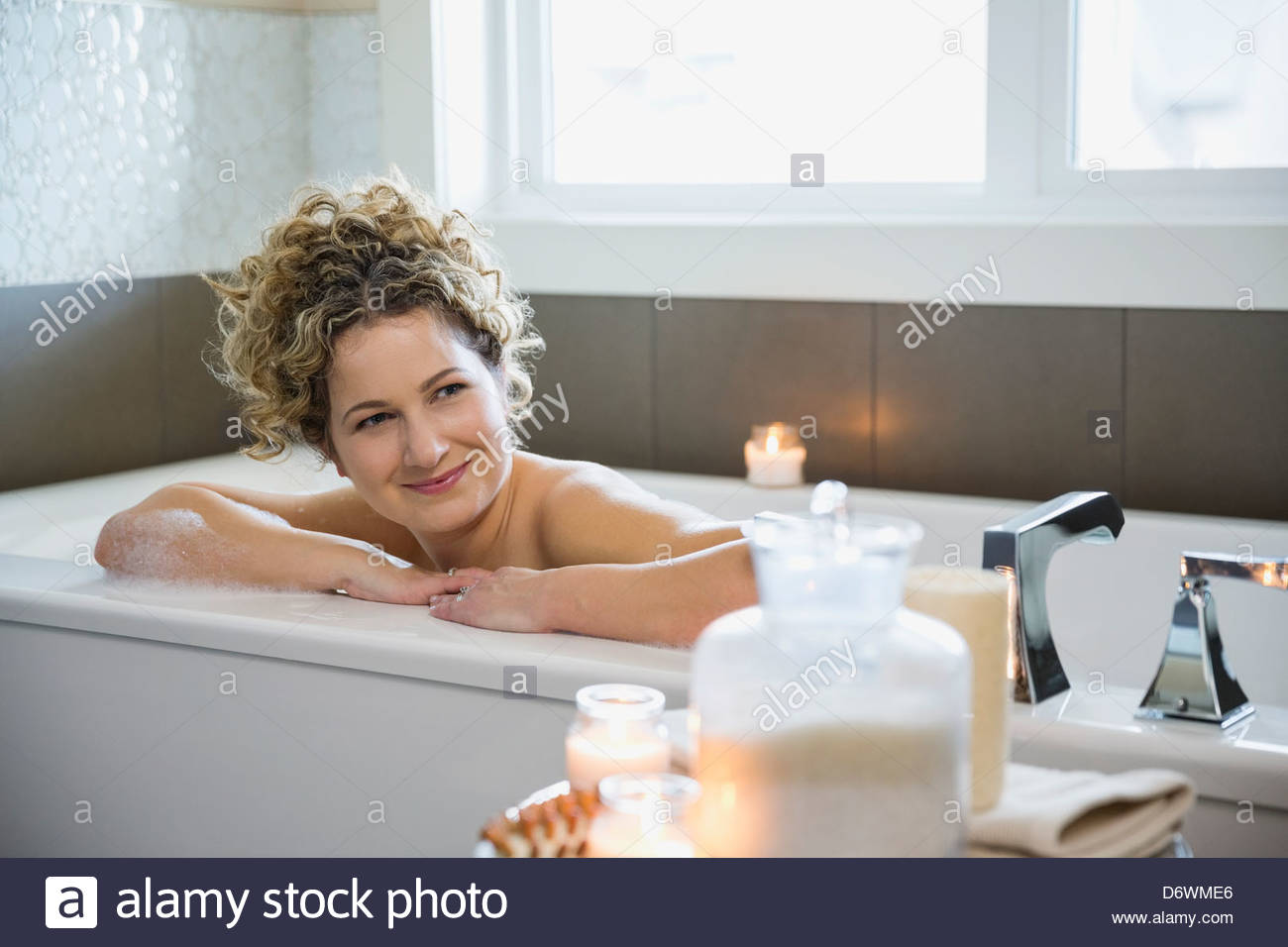 Reife Frau wegsehen beim Entspannen in der Badewanne Stockfoto