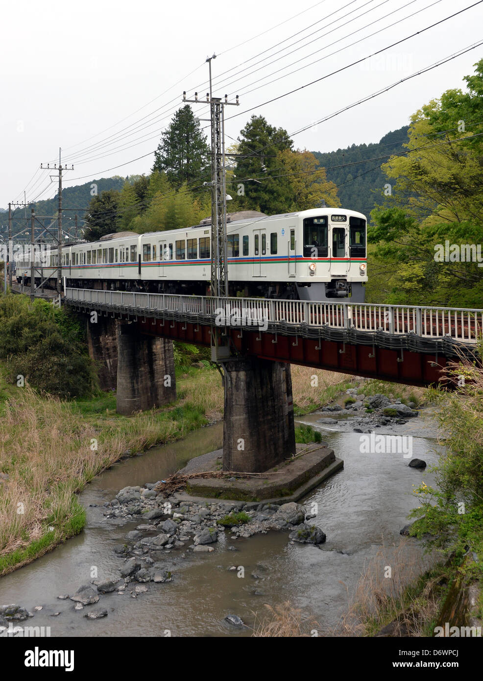 23. April 2013, Hanno, Japan - gebunden A Seibu Railway Co. Zug für Chichibu, etwa 112 km nordwestlich von Tokio, eine Brücke in der Nähe von Musashi-Yokote Station des Unternehmens 19 km Seibu Chichibu Linie auf Dienstag, 23. April 2013 überquert.  US-Equity-Fonds Cerberus Capital Management hat ein Übernahmeangebot zu steigern ihren Anteil von derzeit 32 Prozent auf knapp 45 Prozent in einem scheinbaren Gebot Eigeninitiative bei der Verwaltung von Seibu Holdings, Bahnhof und Hotel Betreiber gemacht. Gerüchte, die die US-Investmentgesellschaft fordert, dass die unrentablen Amtsleitung geschlossen werden gemacht, lokale Gouverneur und Gemeinschaft führen Stockfoto