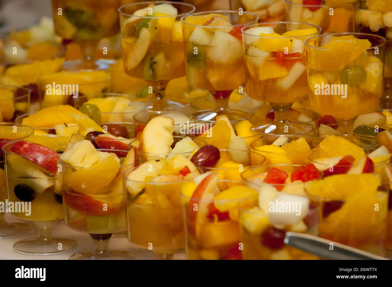 Reihen von Obstsalaten, serviert in Stielgläsern. Stockfoto