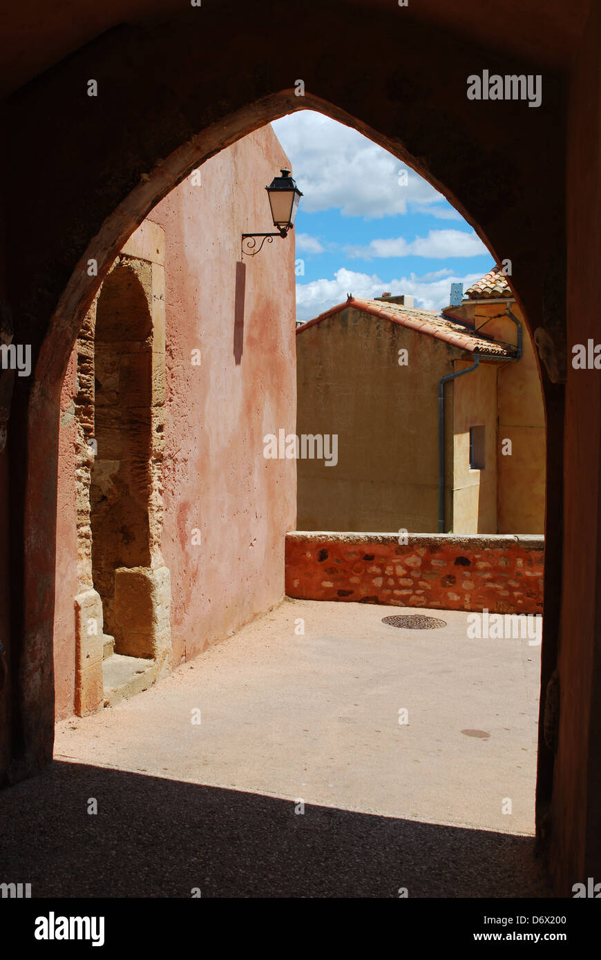 Häuser hinter einem Bogen im historischen Ocker Dorf Roussillon, Provence, Frankreich Stockfoto