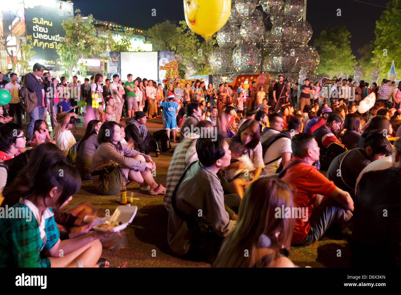 Sitzen öffentlichen ansehen Thai Pop-Show auf der Bühne für Silvester auf dem Thapae Tor Platz, Chiang Mai, Thailand Stockfoto