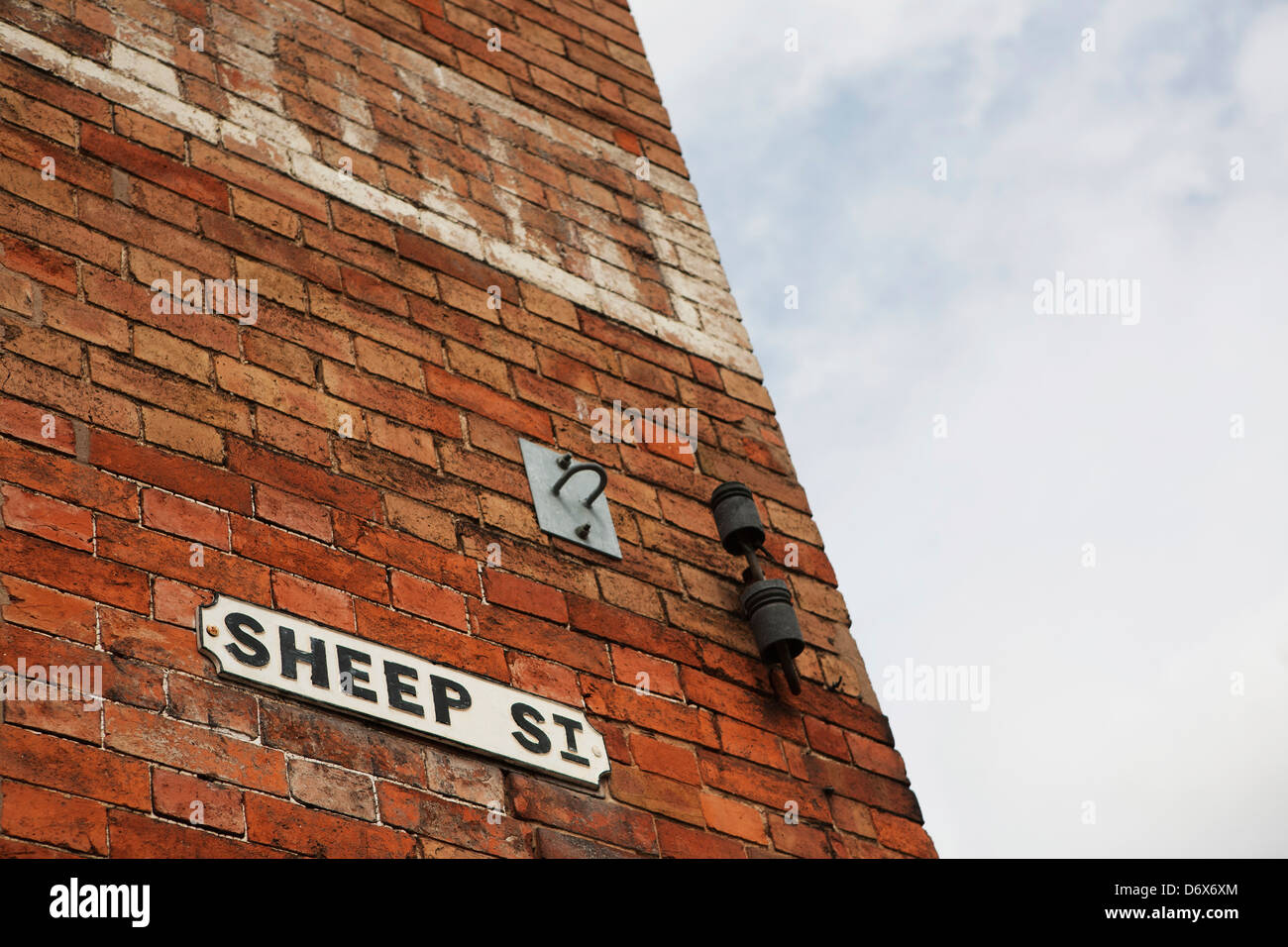 Gusseisen-Straßenschild (Sheep Street) auf viktorianischen roten Backsteinhaus. Stockfoto
