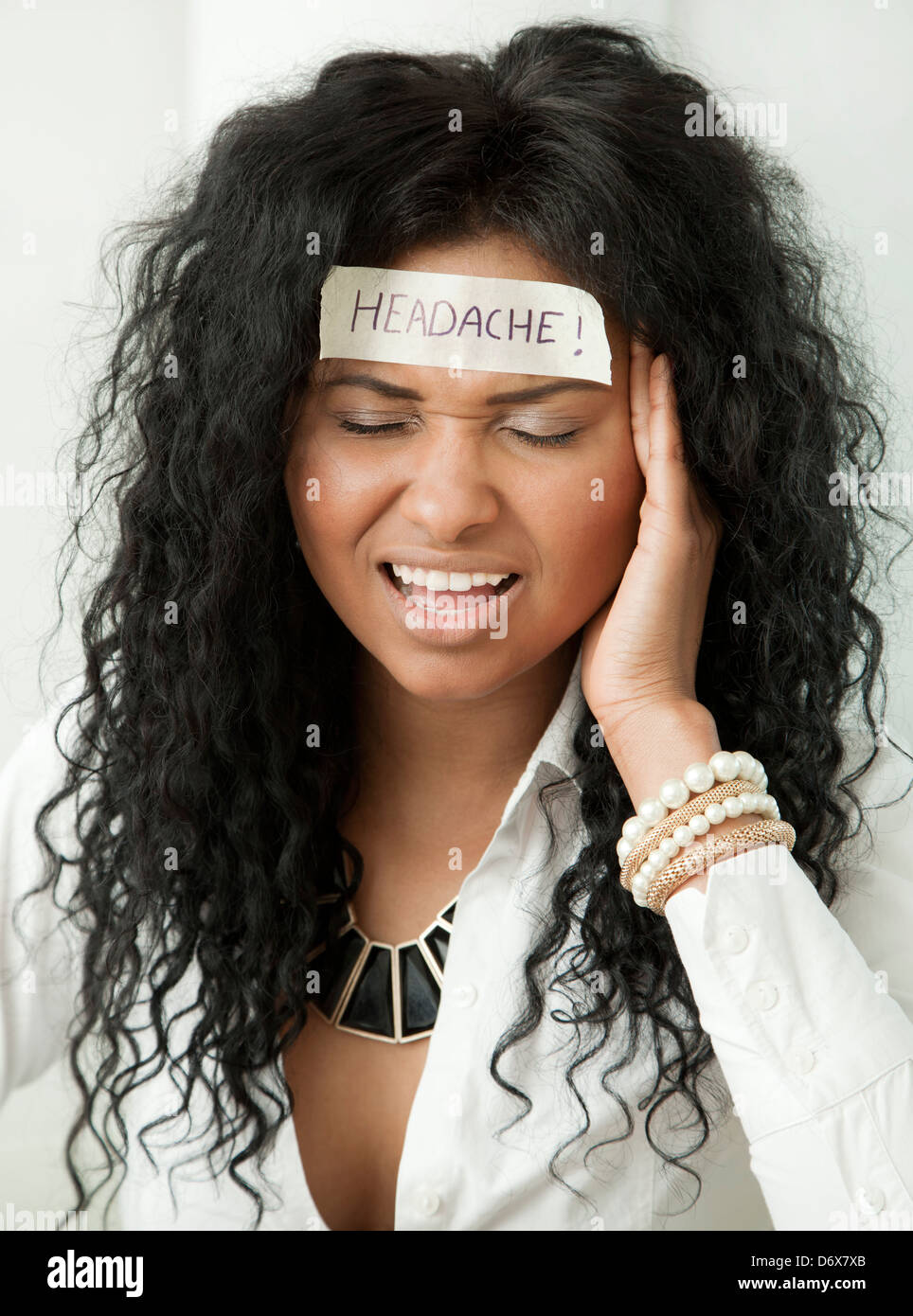 Attraktive junge Frau mit Kopfschmerzen Stockfoto