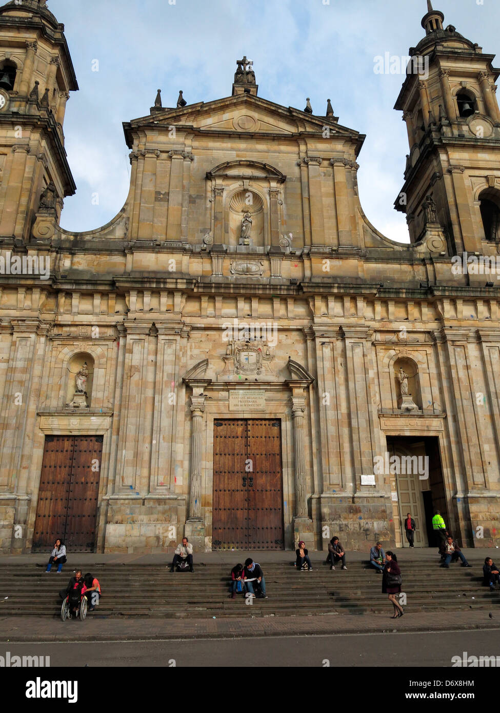 Menschen sitzen auf den Stufen des Catedral Primada in Plaza de Bolivar. Stockfoto