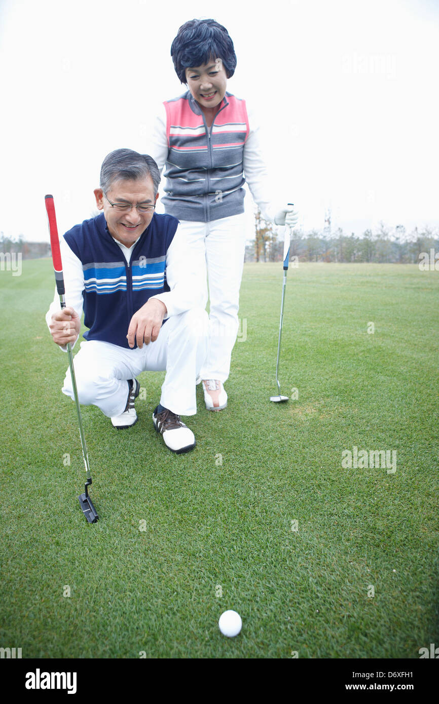 ein paar beobachten am Golfball auf dem Rasen Stockfoto