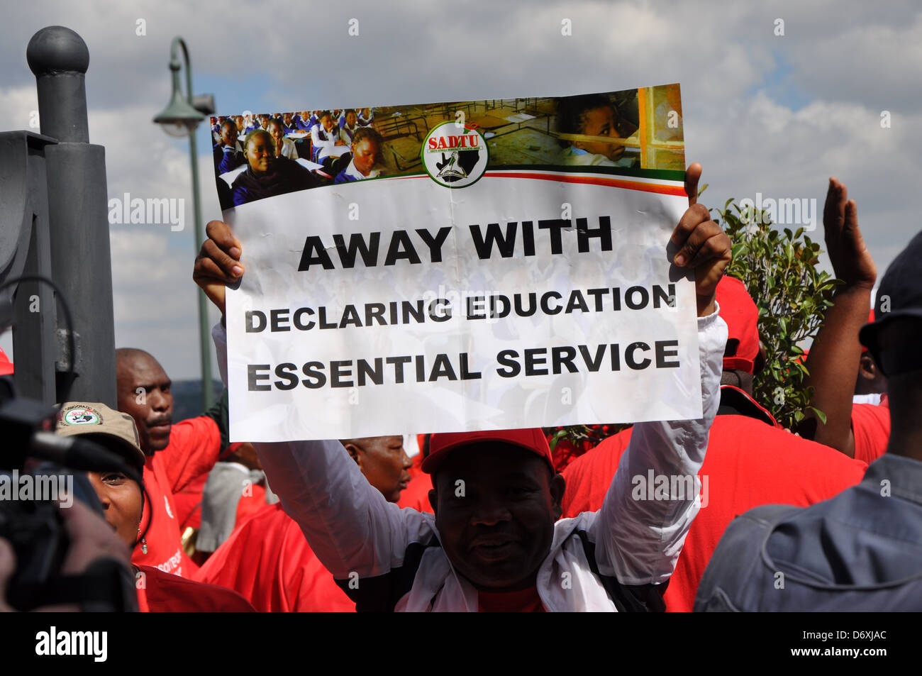 Demonstrant heben Sie ein Plakat, das liest: "Fort mit deklarieren Bildung Grundversorgung". Stockfoto