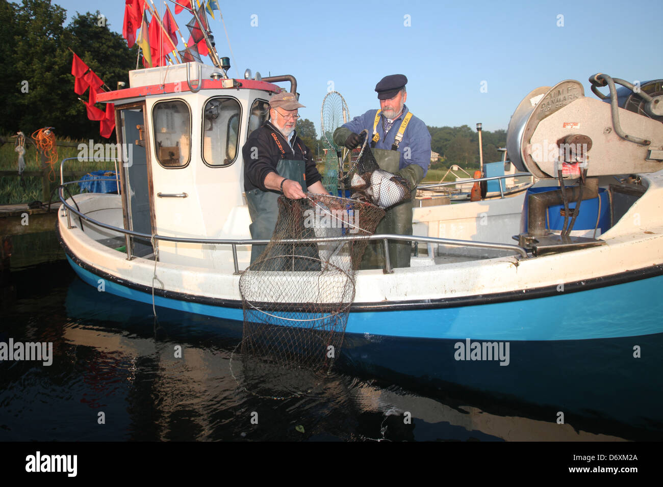 Flensburg, Deutschland, Teilzeit Fischer säubern ihre Netze nach der Arbeit am Dock in Fahrensodde Stockfoto