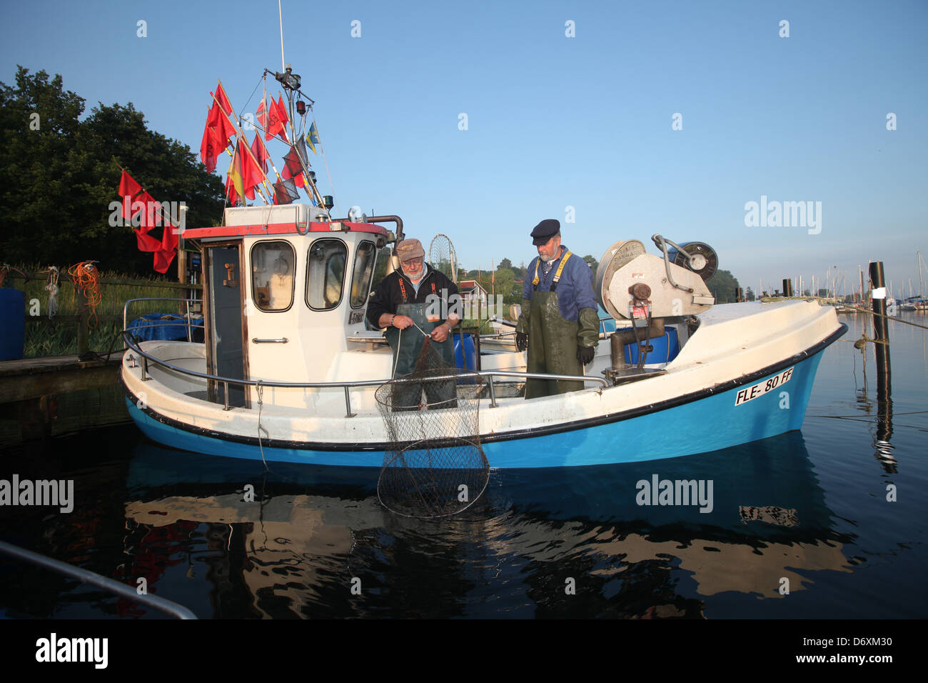 Flensburg, Deutschland, Teilzeit Fischer säubern ihre Netze nach der Arbeit am Dock in Fahrensodde Stockfoto