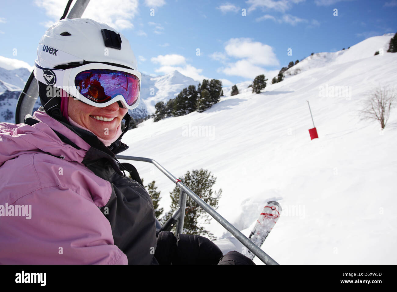 Lächelndes Mädchen mit einem Sessellift. Skifahren in Meribel, Frankreich Stockfoto