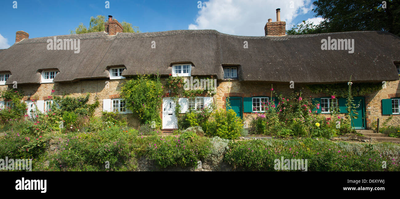 Malerischen traditionellen strohgedeckten Hütten, Rose-bedeckt, bei Clifton Hampden in Oxfordshire, Vereinigtes Königreich Stockfoto