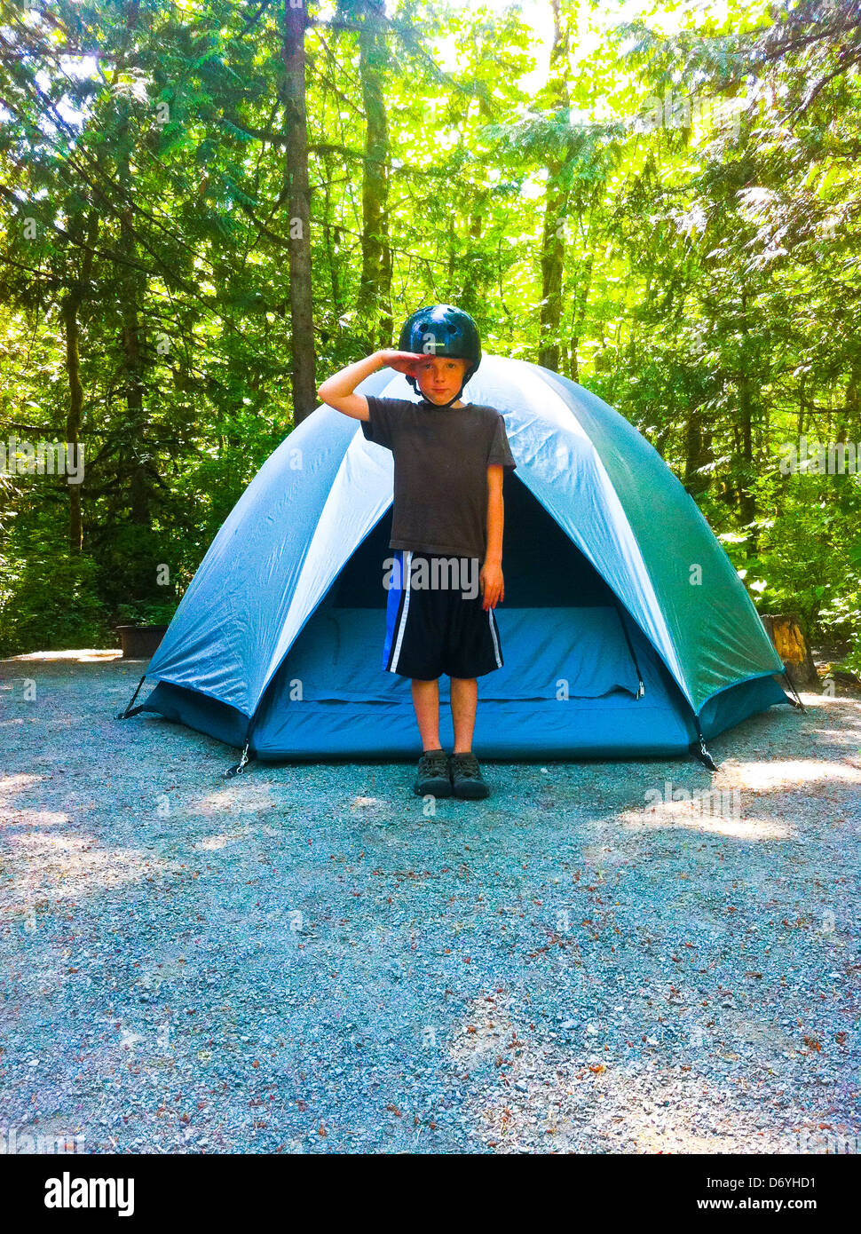 Kaukasische junge im Helm stehen vor Zelt - Smartphone-aufgenommenes Stockfoto