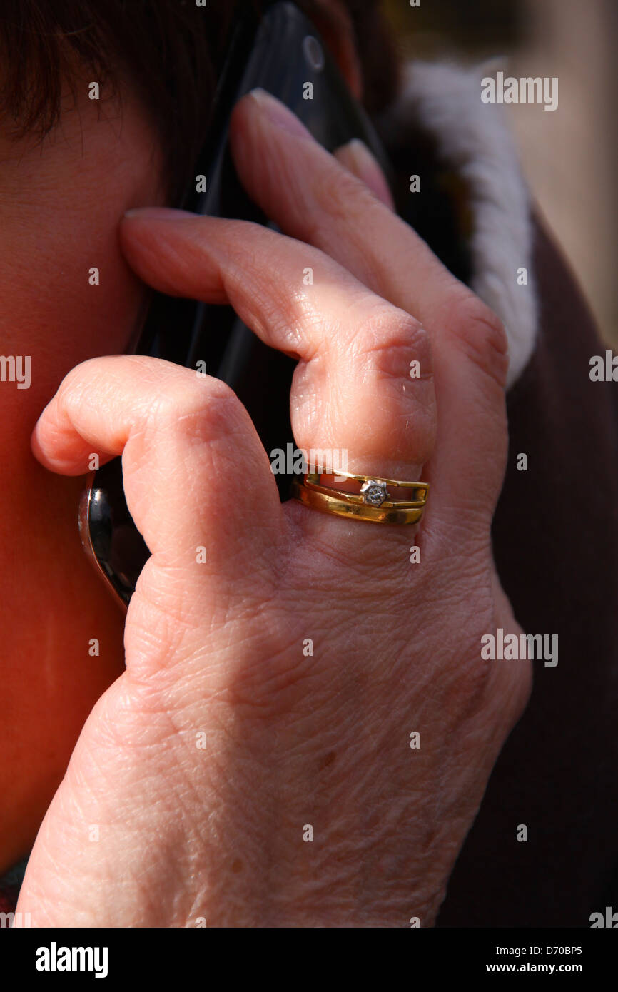 Applying verheiratete Frau halten iPhone zum Ohr Stockfoto