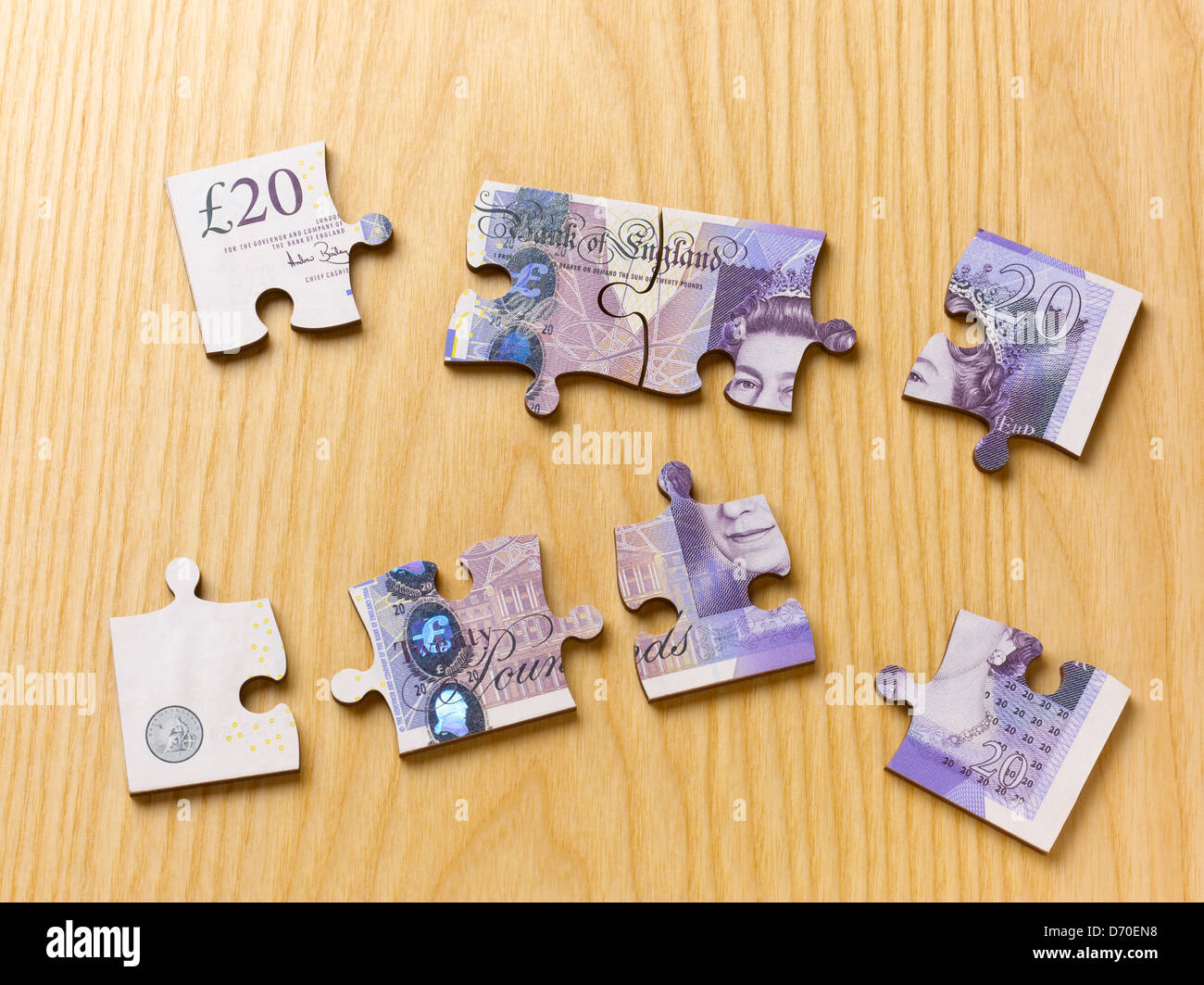 Britische Währung zwanzig Pfund Hinweis Jigsaw Puzzle in Stücken, am Schreibtisch aus Holz Stockfoto