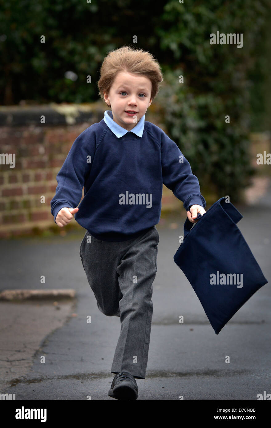 Ein fünf Jahre alter Junge seiner Schule, die einheitliche entlang ein Pflaster tragen. Stockfoto