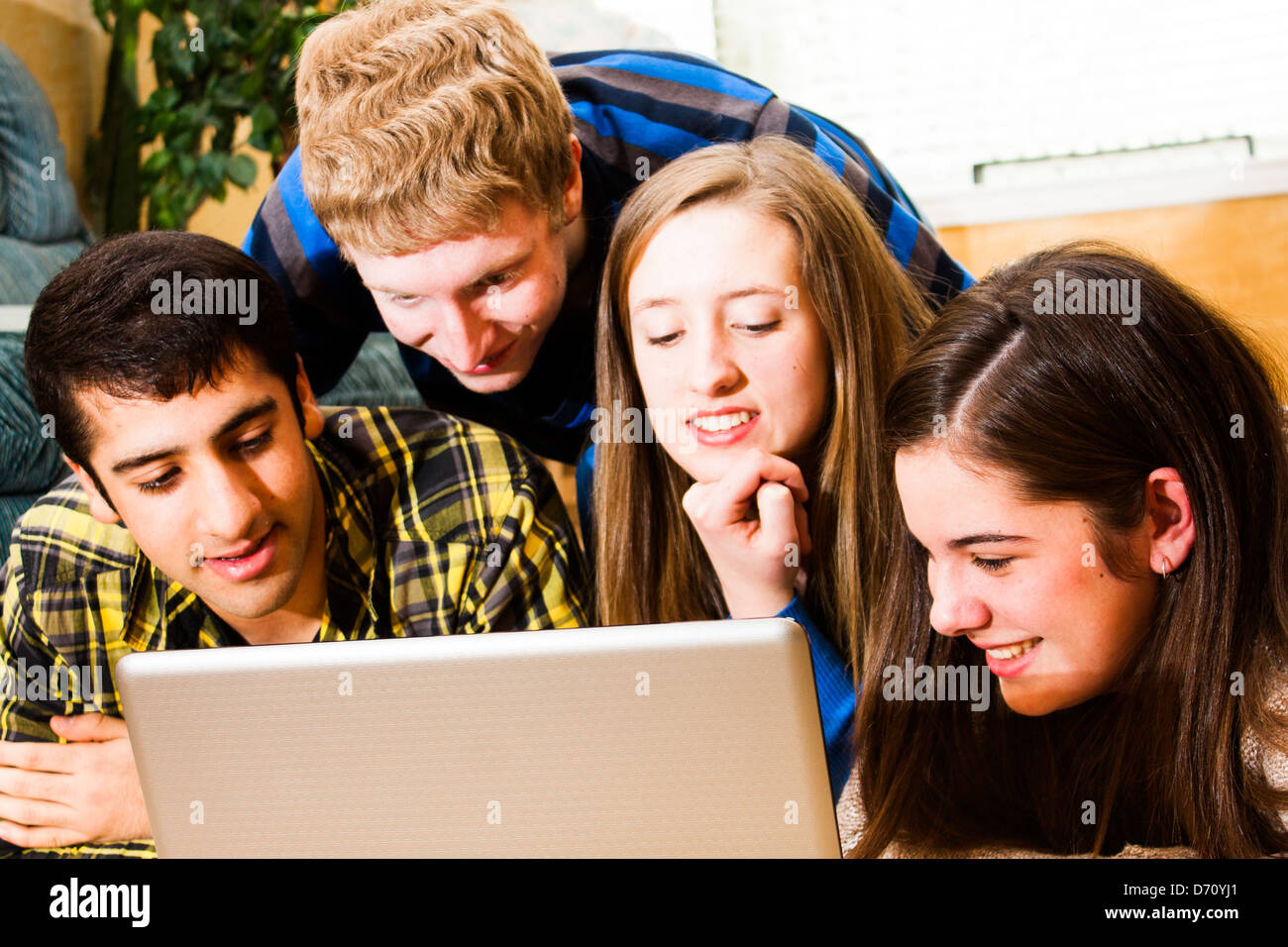 eine Gruppe von Jugendlichen, die gemeinsam einen Computer-Bildschirm anzeigen. Hohe Sättigung. Stockfoto