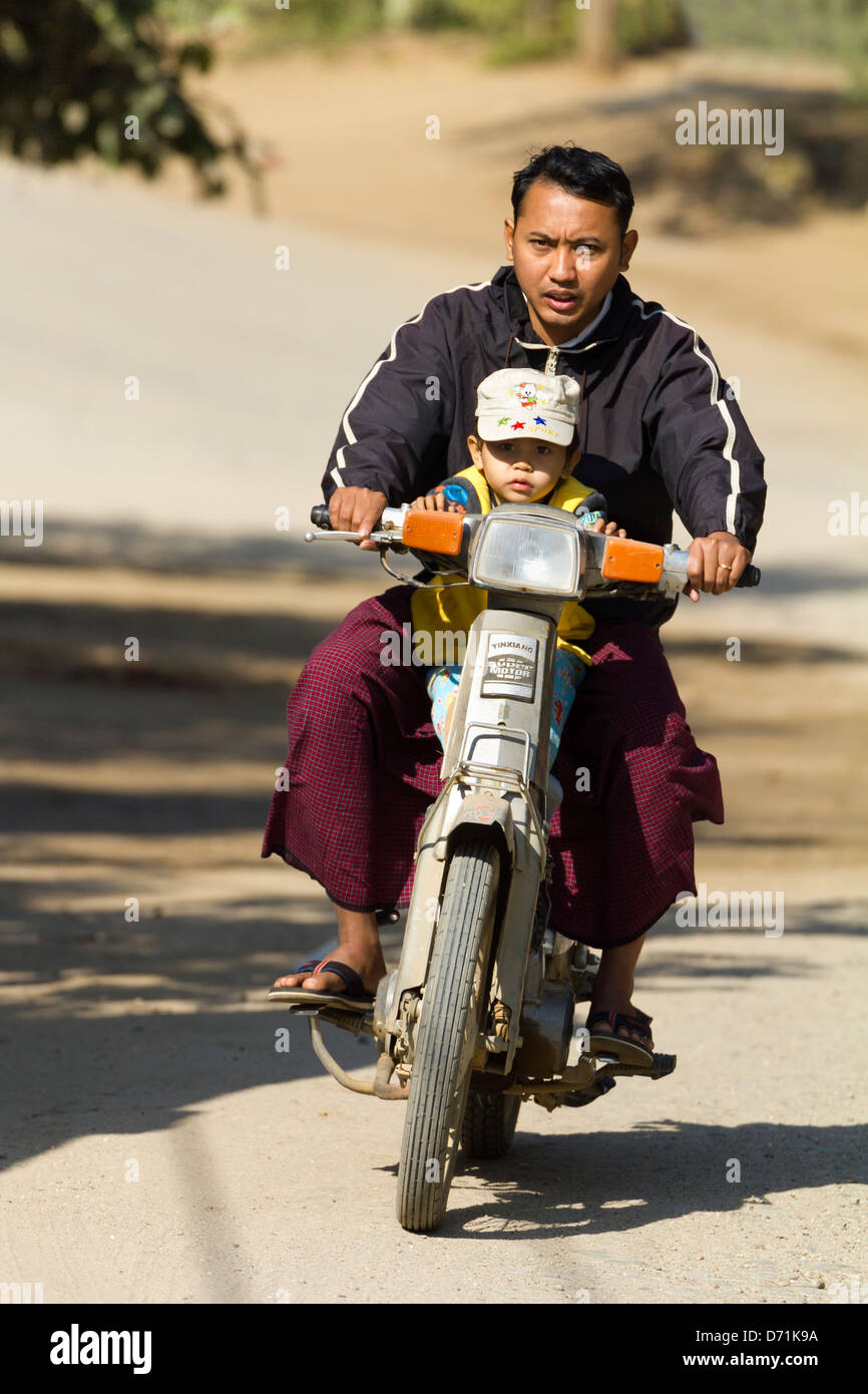 Vater und Kind reiten auf einem Moped in Bagan, Myanmar 2 Stockfoto