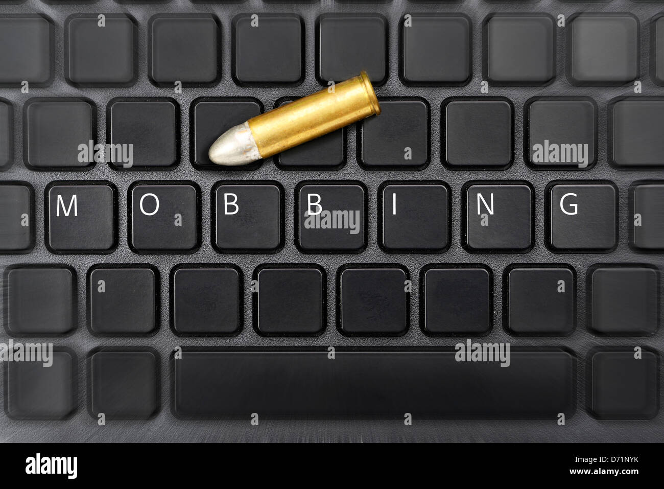 Das Wort Mobbing auf eine Computer Tastatur und Gewehr Patrone, Online-Belästigung Stockfoto