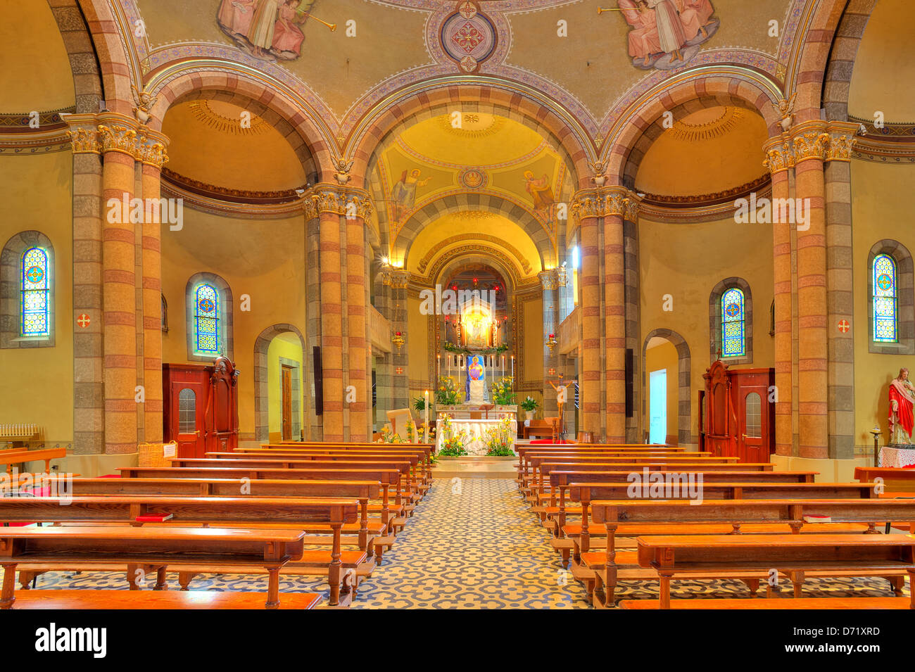 Bänke und Altar zwischen den Spalten im Rahmen der Innenansicht der Madonna Moretta katholische Kirche in Alba, Norditalien. Stockfoto