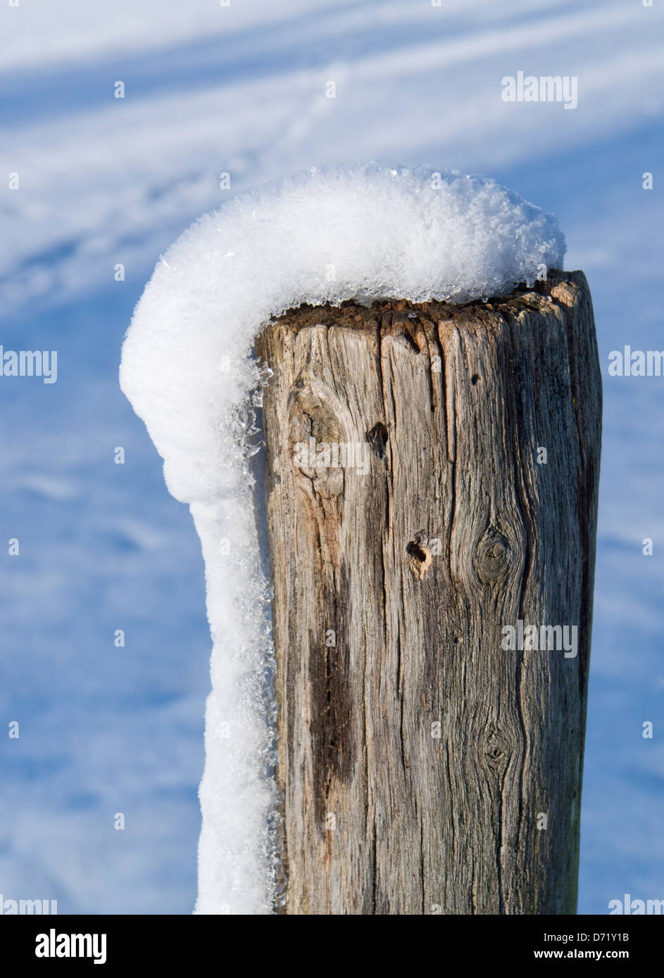 Detail einer verschneiten hölzerne Stange im winter Stockfoto