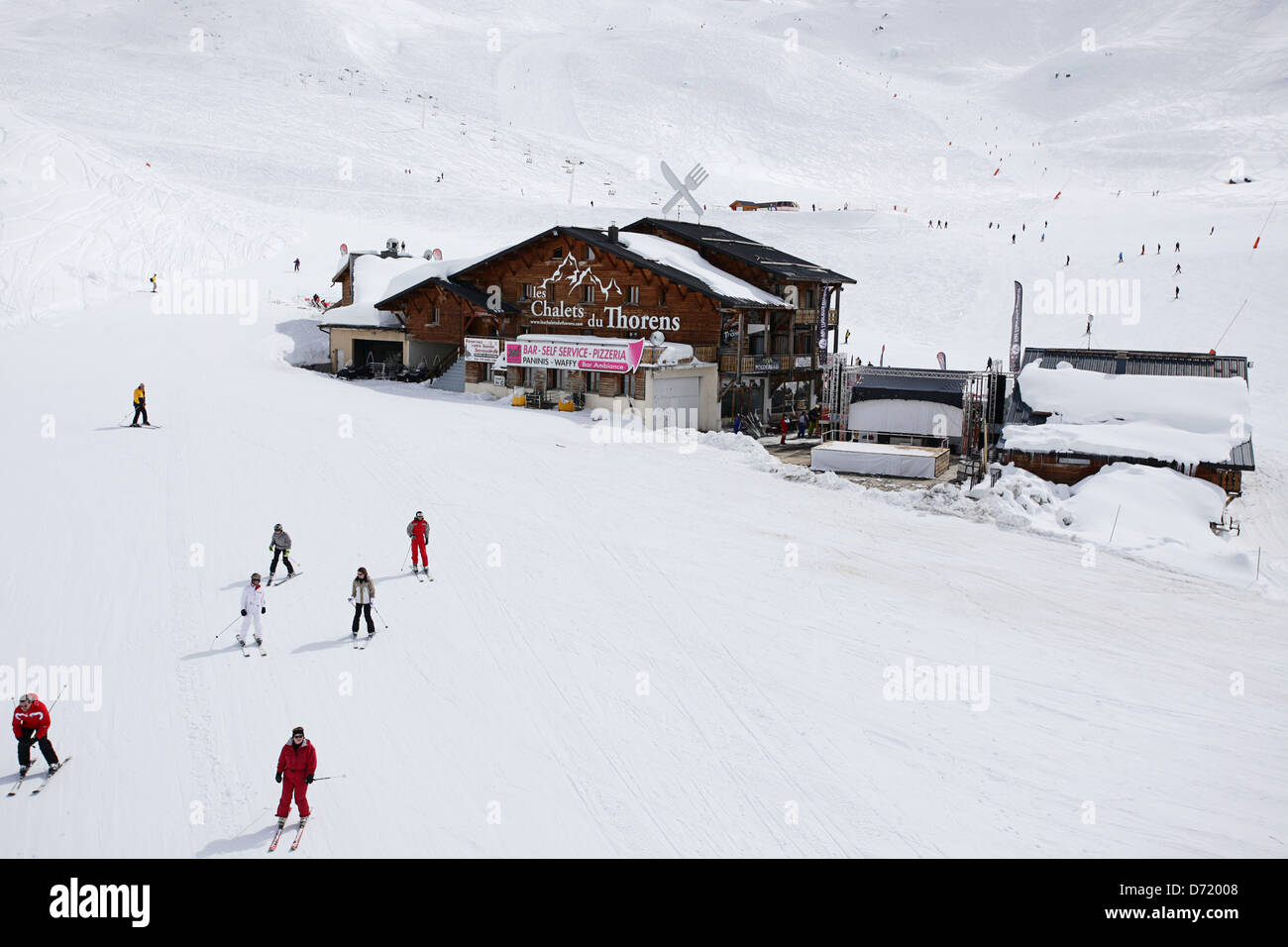 Les Chalets du Thorens mit Skifahrer in den Vordergrund & Hintergrund. Art-Foto aus einem Skiurlaub in den französischen Alpen zu reisen. Stockfoto