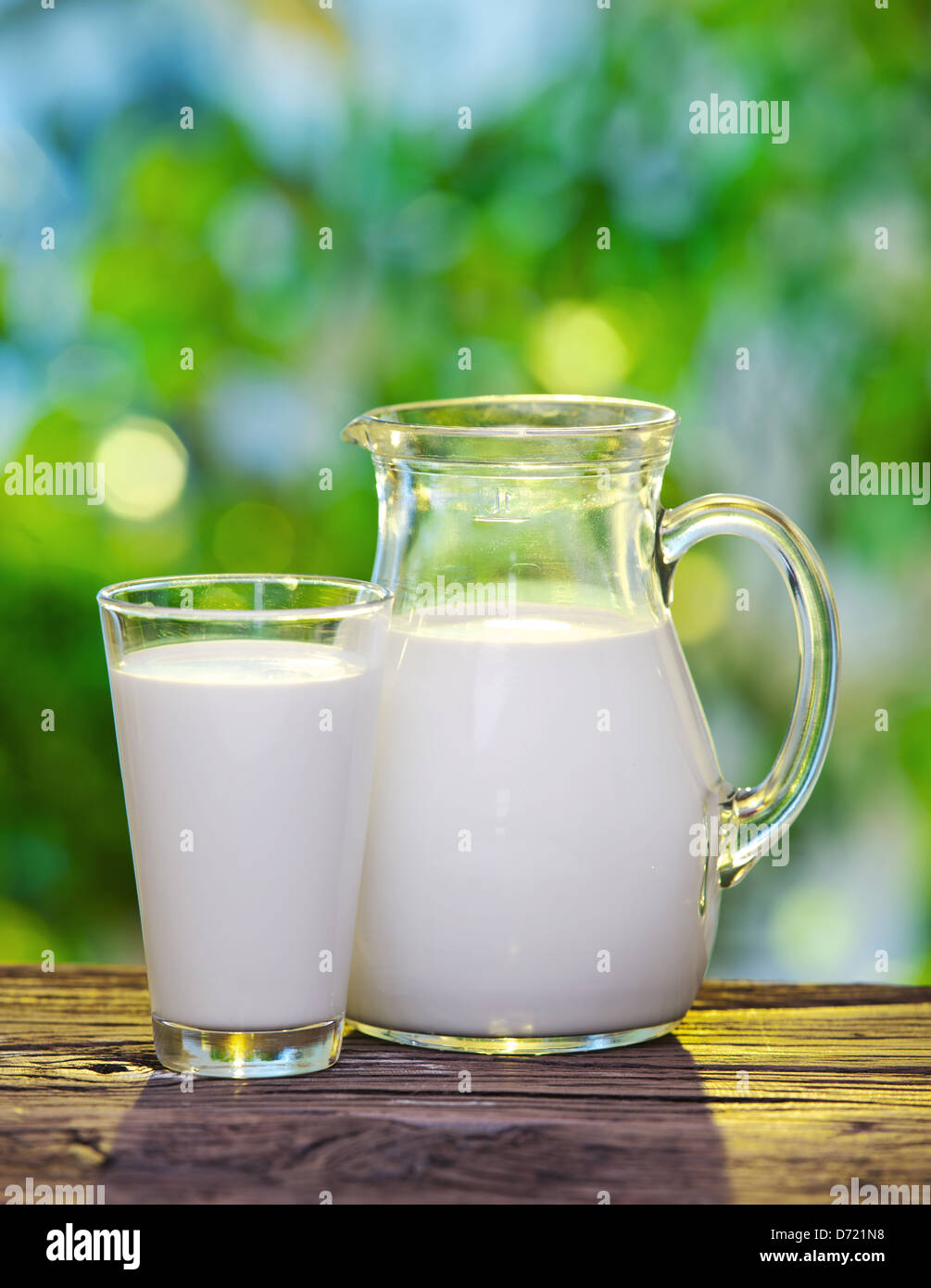 Milch im Glas und Glas auf dem alten Holztisch auf einer im Freieneinstellung. Stockfoto