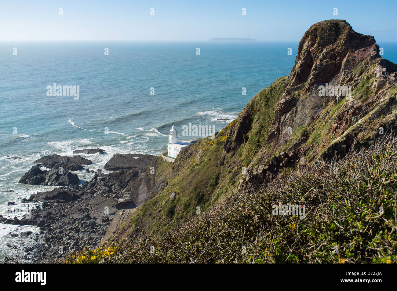 Hartland Point, Hartland, North Devon, England. Harland Point Lighthouse am Fuße der Klippen mit Lundy Island. Stockfoto