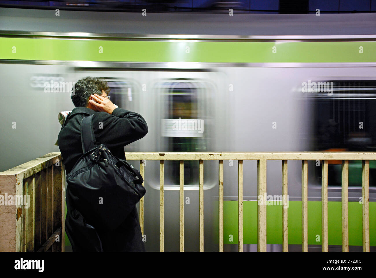 Ein Unternehmer wartet auf seinen Zug an einer u-Bahnstation in Tokyo, Japan. Stockfoto