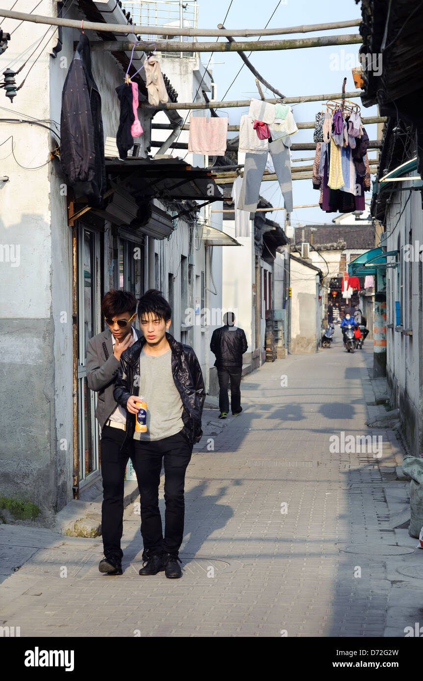 Zwei junge Männer gehen Sie eine Gasse in der alten Stadt Bezirk von Suzhou, China Stockfoto