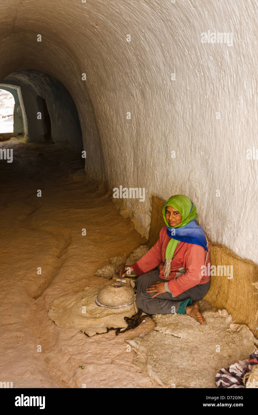 Frau Schleifen Weizen in Höhlenwohnungen Wohnungen (Häuser unterirdisch gebaut), Matmata, Tunesien Stockfoto