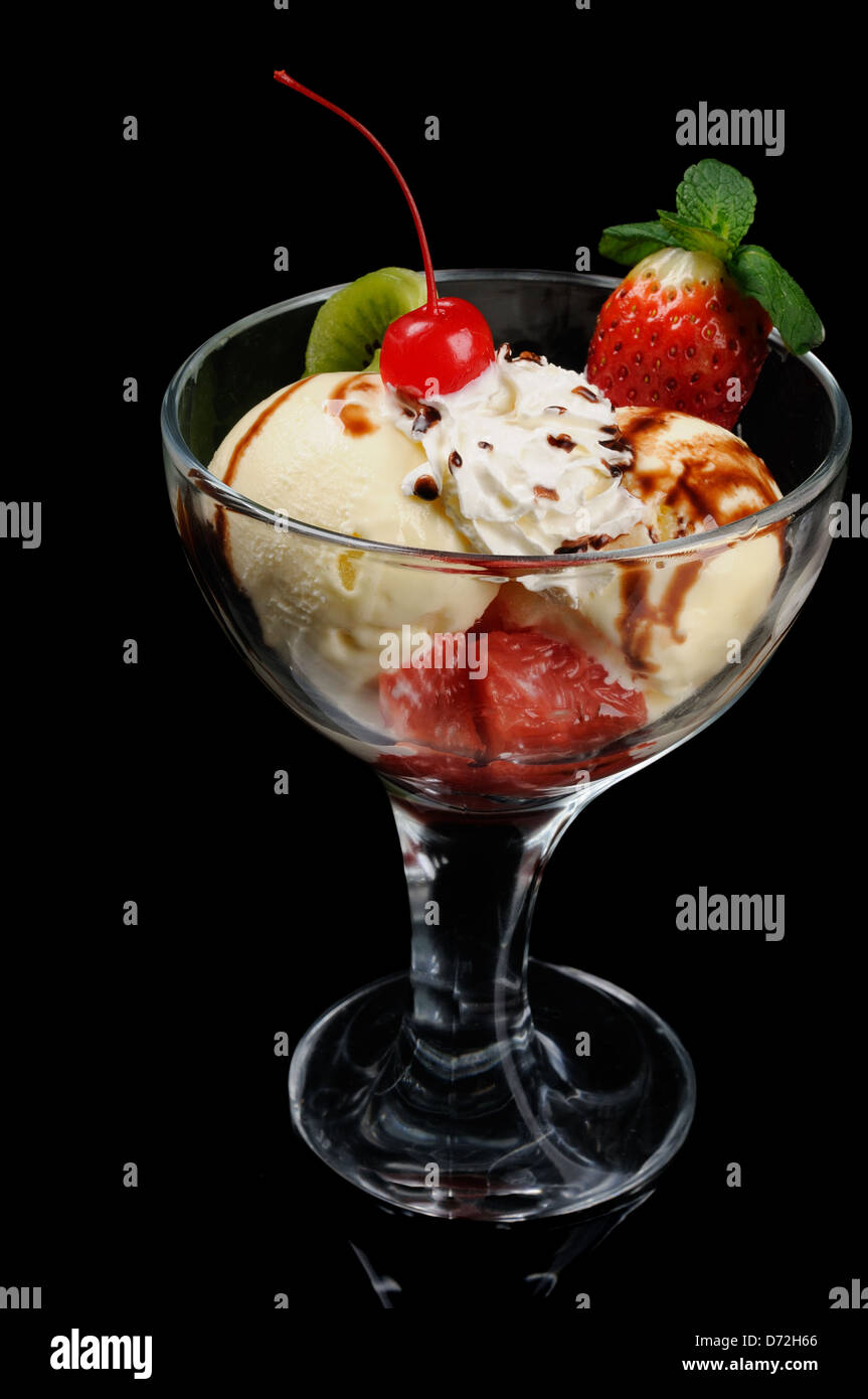 Lecker Eis dekoriert mit Früchten auf schwarzem Hintergrund Stockfoto