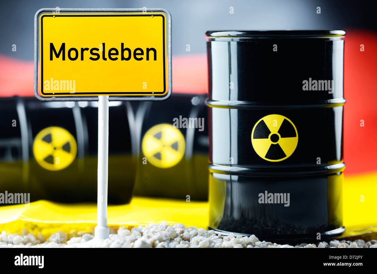 Drei nukleare Abfälle Fässer vor eine Deutschland Fahne und lokalen Schild mit Beschriftung Morsleben Stockfoto