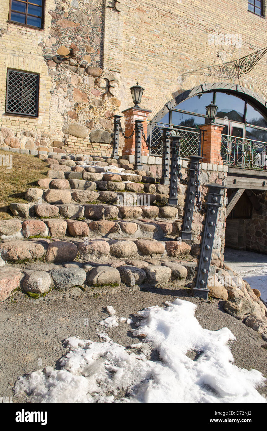 Stein cobby Treppe mit Geländer aus Stahl und Lampe zu Retro-Manor und Schnee bleiben im Frühjahr. Stockfoto