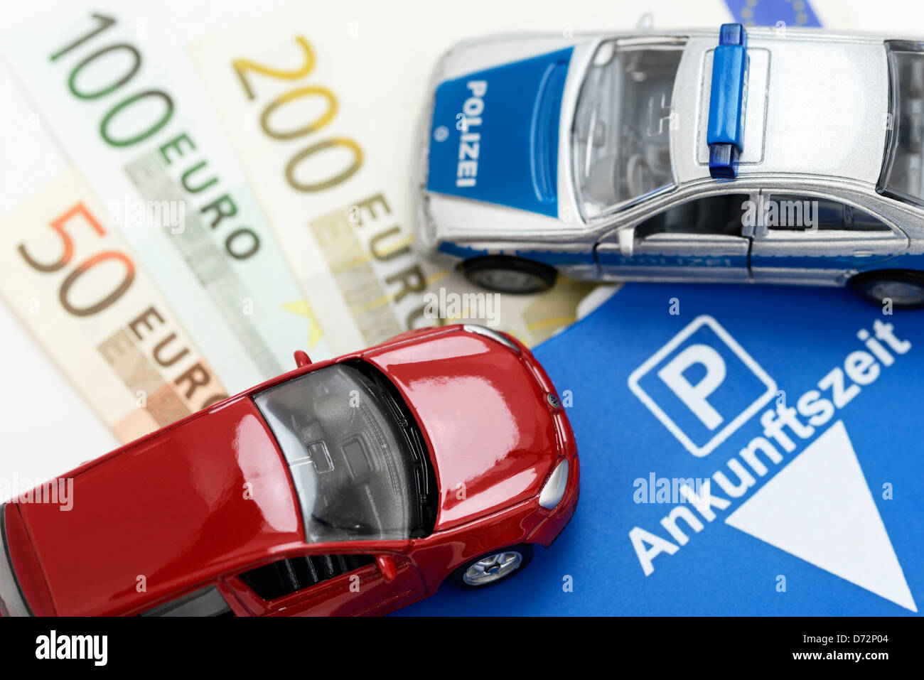 Miniatur-Auto, Banknoten und Parkscheibe, höhere Strafen für Falschparker Stockfoto