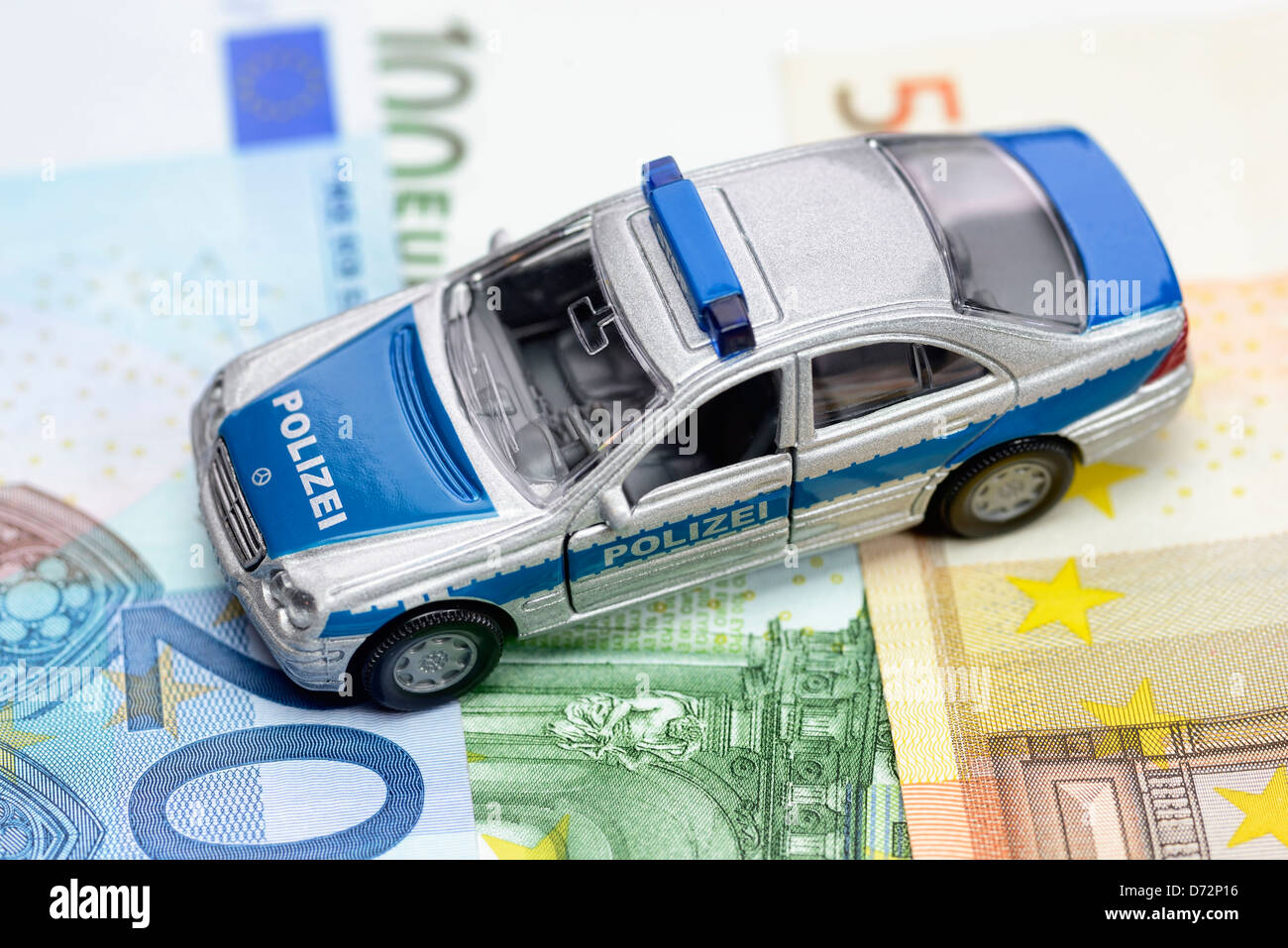 Polizei-Miniatur-Auto auf Euro-Banknoten Stockfoto