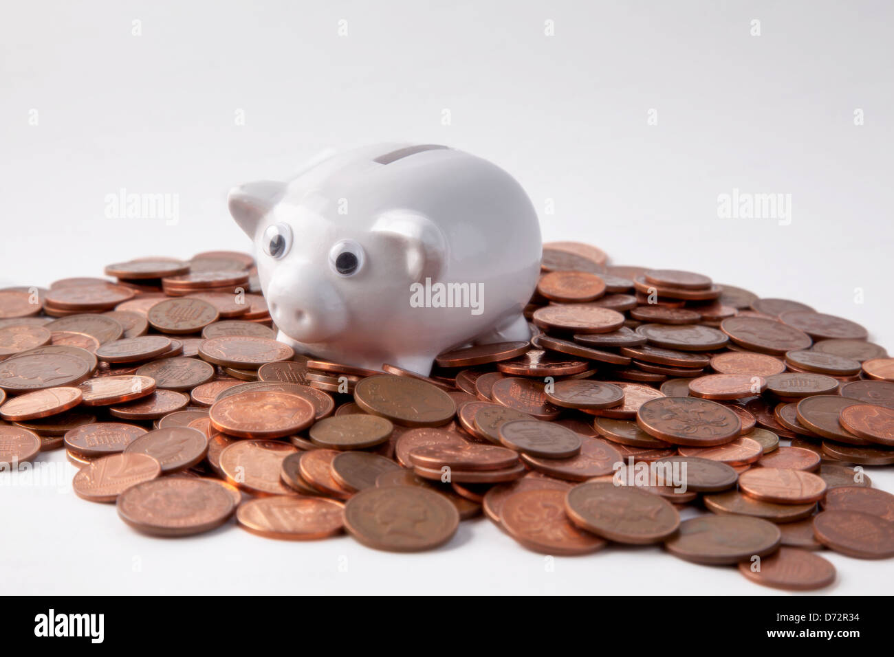 Sparschwein und Pennies auf weißem Hintergrund Stockfoto