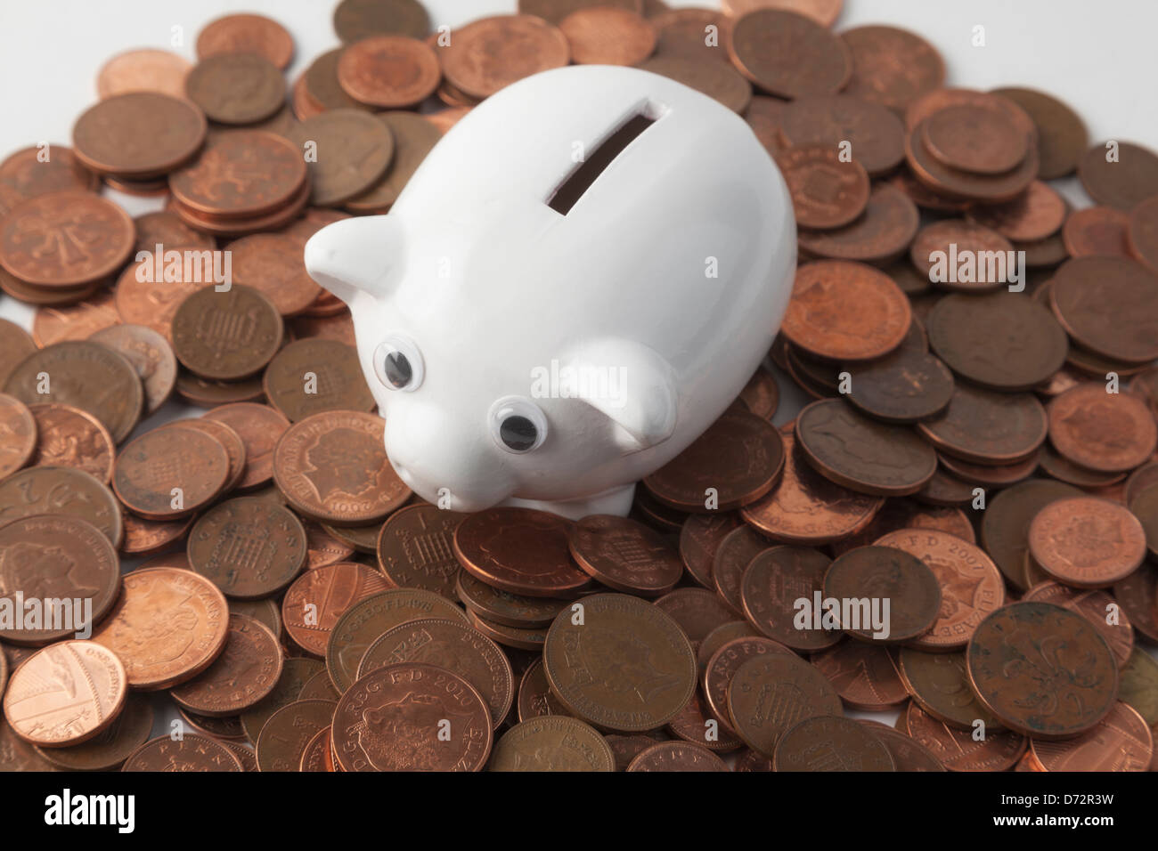 Sparschwein und Pennies auf weißem Hintergrund Stockfoto
